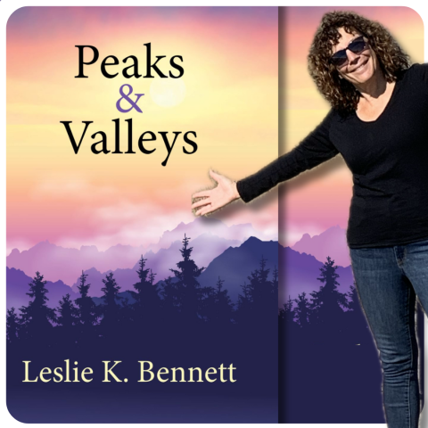"Peaks & Valleys" by Leslie K Bennett. Smiling woman with sunglasses and a moody mountainous background.
