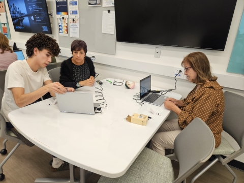 a person teaching another person with a computer 
