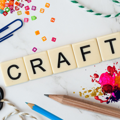 Scrabble tiles that spell out craft with beads and pencils surrounding them