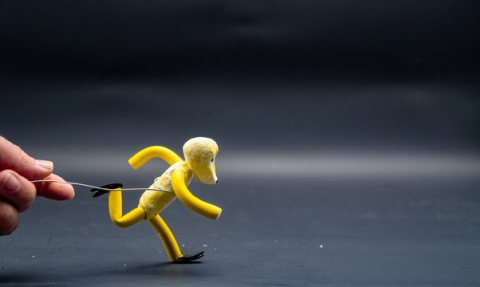 Human figure in running pose, crafted from yellow clay