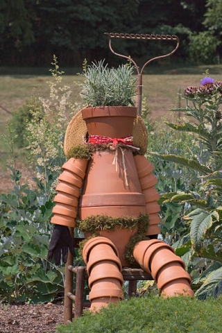 Human figure constructed from terra cotta pots in a garden
