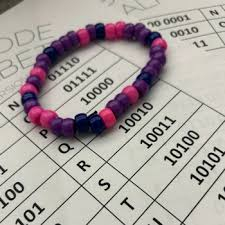 image of beaded bracelet on top of a worksheet for learning binary code