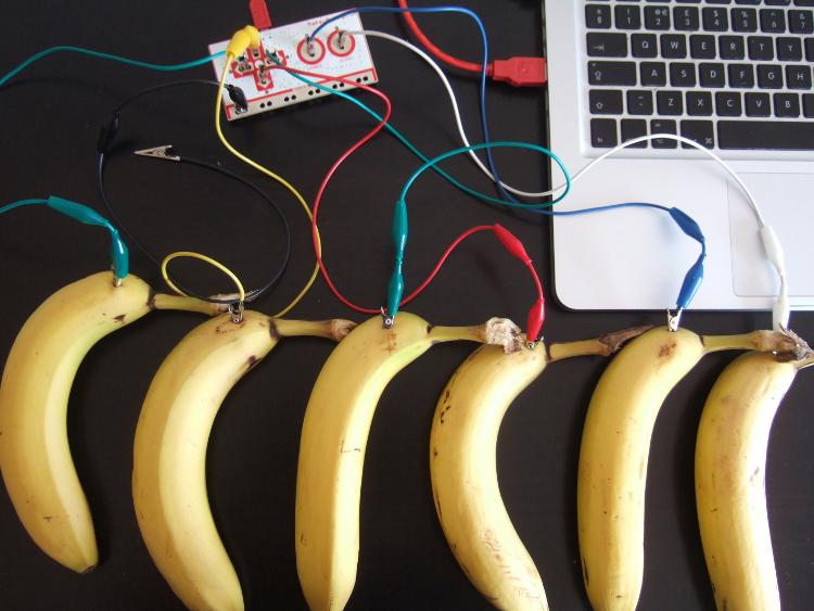 six bananas connected to a keyboard with wires through a Makey Makey circuit board